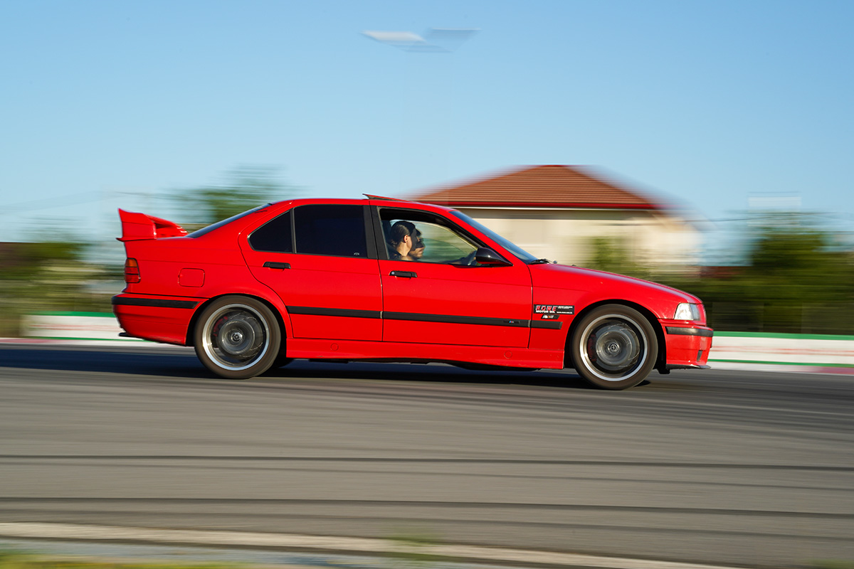 Motocicletă neagră cu pilot în echipament roșu și galben