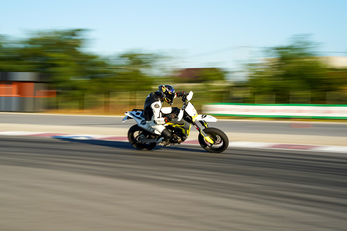 BMW E36 roșu cu eleron în mișcare pe pistă