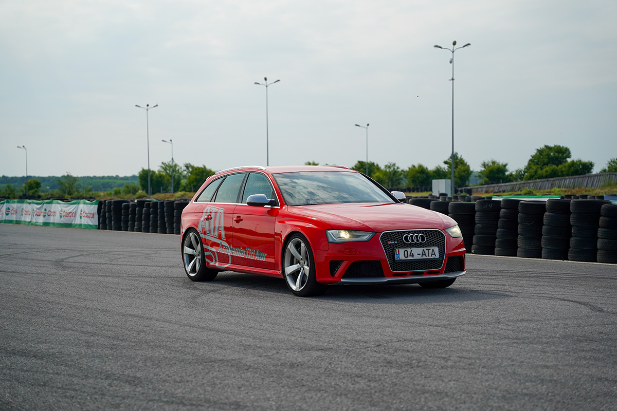 Motocicletă supermoto albă și galbenă cu pilot în viraj