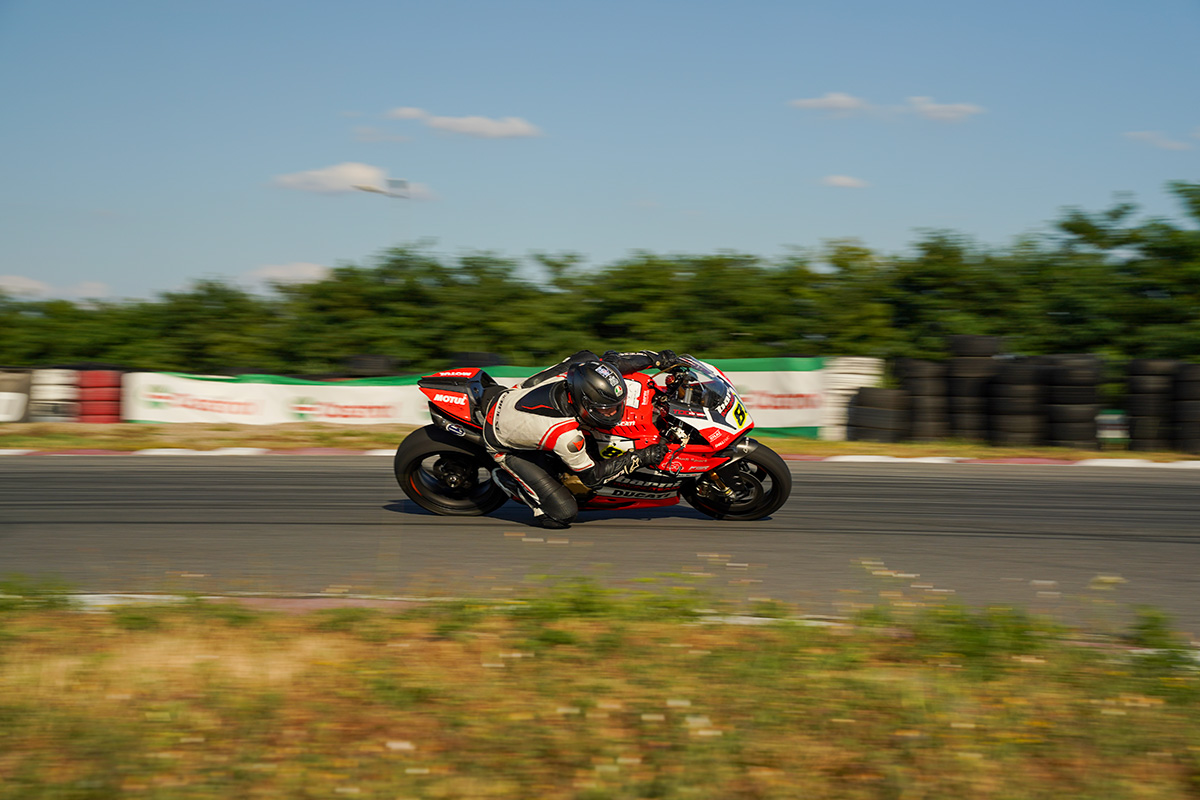 Ducati roșie cu pilot în viraj pe pistă